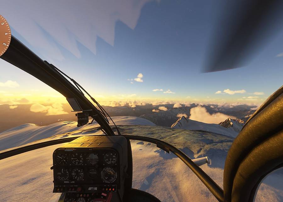 Vue du cockpit au-dessus des sommets enneigés au coucher du soleil, sur le simulateur de vol hélicoptère HélicoSimu